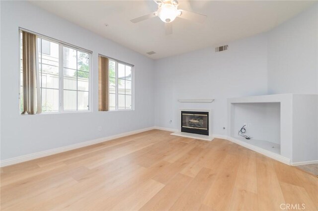 807 Yorkshire, Irvine, CA 92620 - unfurnished living room featuring light wood-type flooring, baseboards, ceiling fan, and a glass covered fireplace