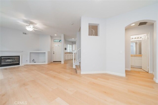 807 Yorkshire, Irvine, CA 92620 - unfurnished living room with ceiling fan, arched walkways, light wood-type flooring, stairs, and recessed lighting