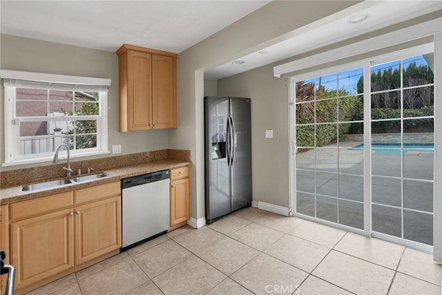 kitchen with stainless steel refrigerator with ice dispenser, white dishwasher, plenty of natural light, and sink