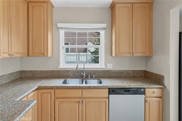 kitchen featuring light brown cabinetry, light stone counters, sink, and stainless steel dishwasher