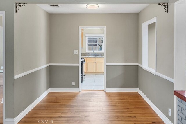 empty room featuring hardwood / wood-style flooring and sink