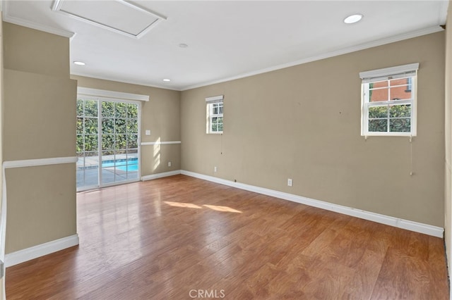 unfurnished room with ornamental molding, hardwood / wood-style flooring, and a healthy amount of sunlight