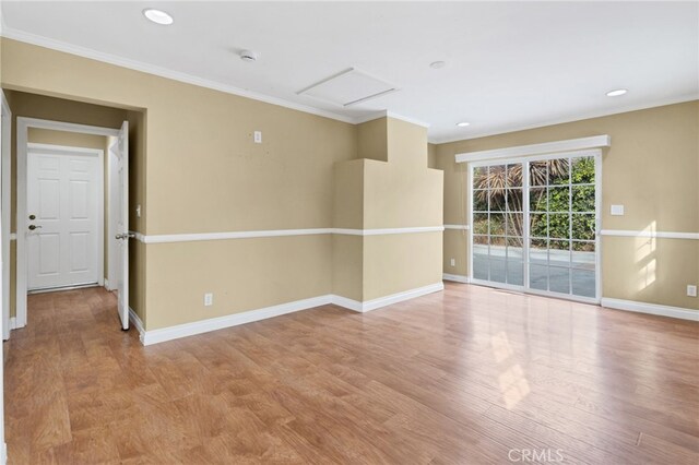 spare room featuring ornamental molding and light wood-type flooring