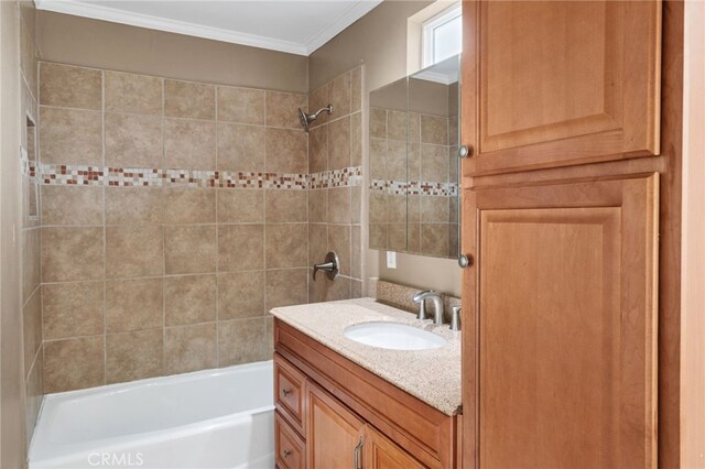 bathroom featuring vanity, crown molding, and tiled shower / bath