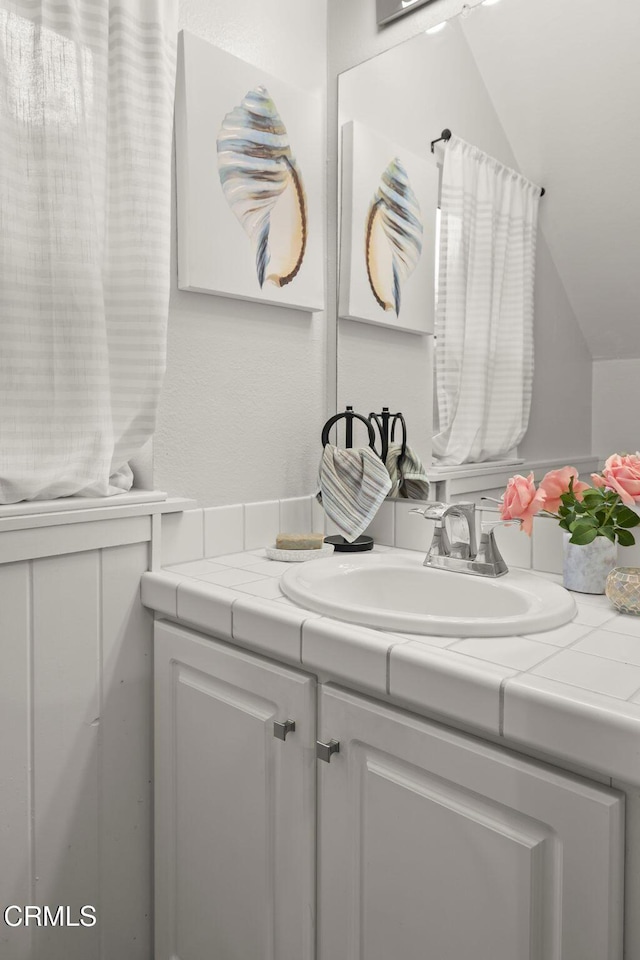 bathroom with vanity and vaulted ceiling