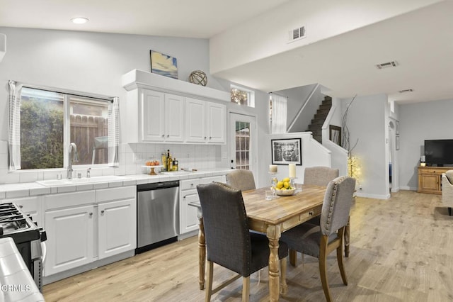 kitchen featuring tile countertops, white cabinetry, dishwasher, and sink