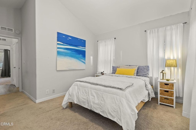 carpeted bedroom with high vaulted ceiling