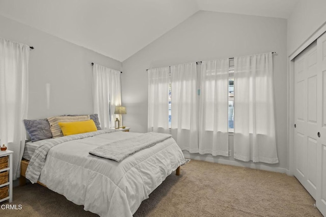 carpeted bedroom with a closet and vaulted ceiling