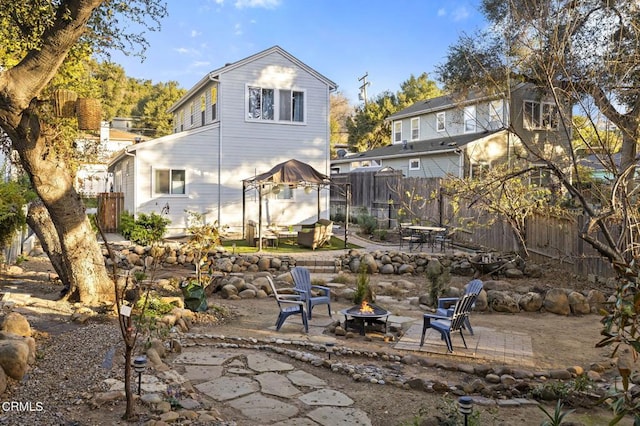 back of property with a patio area and an outdoor fire pit