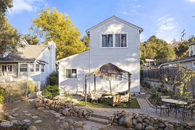 back of house with outdoor lounge area, a gazebo, and a patio area