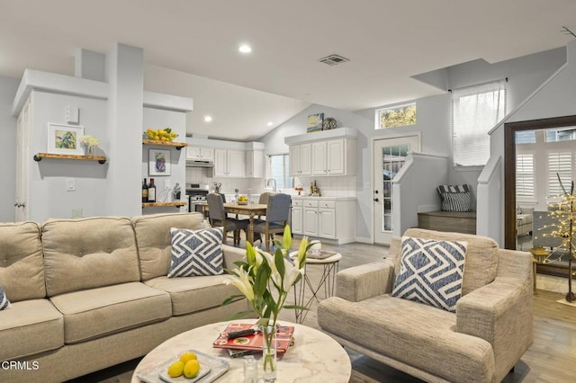 living room with vaulted ceiling and light hardwood / wood-style flooring