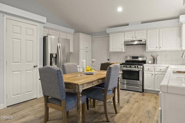 kitchen featuring decorative backsplash, white cabinetry, light hardwood / wood-style flooring, and stainless steel appliances