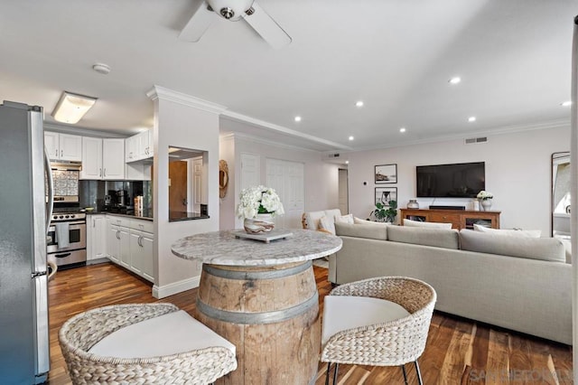 living room with ceiling fan, dark hardwood / wood-style flooring, and ornamental molding