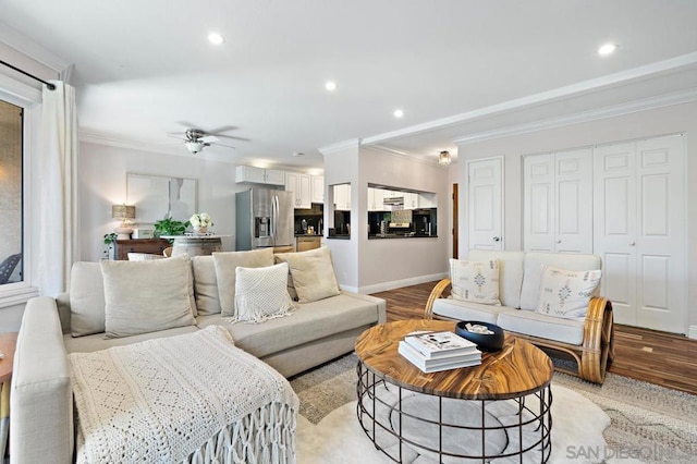 living room featuring ceiling fan, crown molding, and light hardwood / wood-style flooring