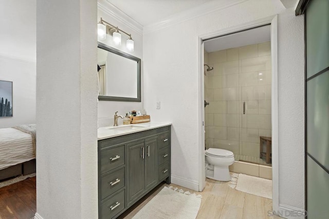 bathroom featuring wood-type flooring, vanity, toilet, walk in shower, and crown molding