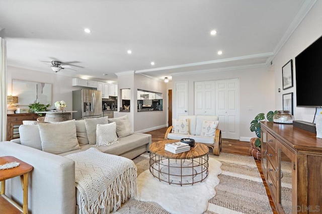 living room with ceiling fan, light wood-type flooring, and ornamental molding