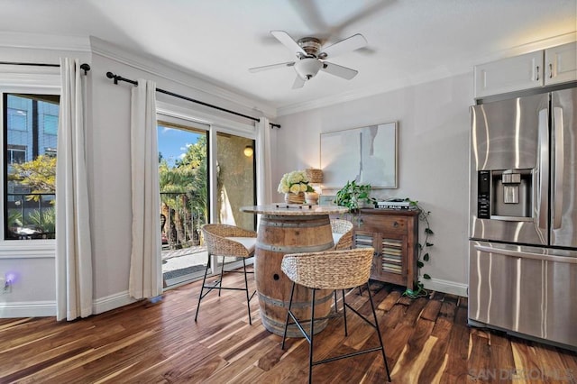 dining space with ceiling fan, dark hardwood / wood-style floors, and ornamental molding