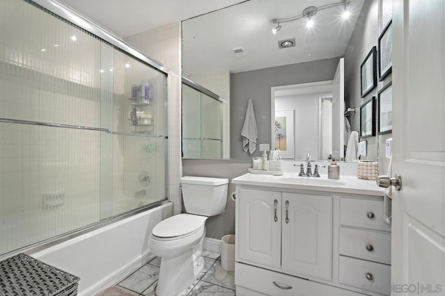 full bathroom featuring toilet, enclosed tub / shower combo, and vanity