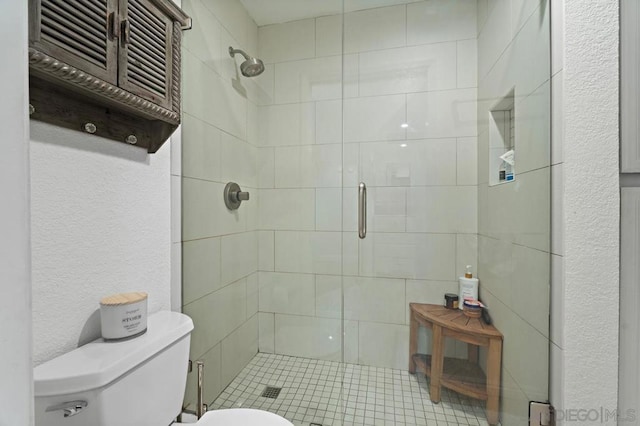 bathroom with toilet and a shower with shower door