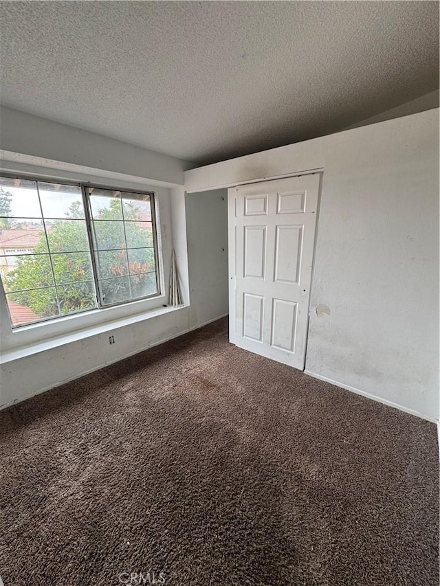 unfurnished bedroom with carpet floors, a closet, and a textured ceiling