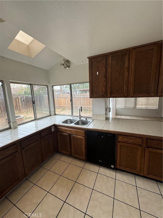 kitchen featuring tile countertops, dishwasher, a sink, and light tile patterned flooring