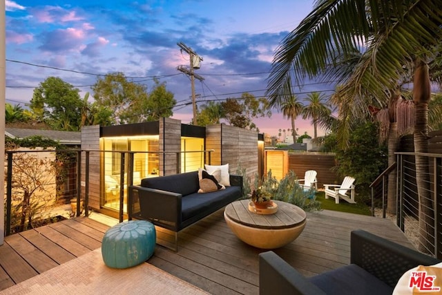 deck at dusk featuring an outdoor hangout area