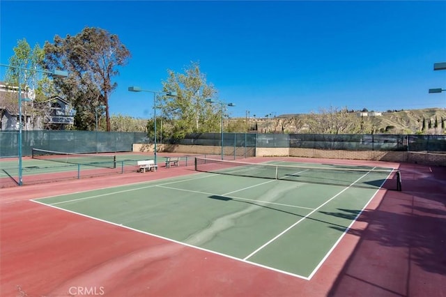 view of tennis court featuring basketball hoop