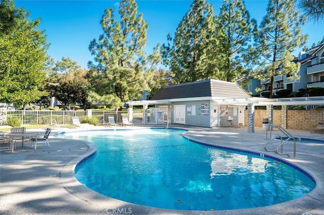 view of swimming pool featuring an outbuilding and a patio area