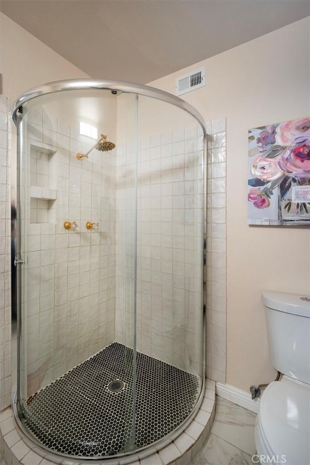 bathroom featuring an enclosed shower and toilet