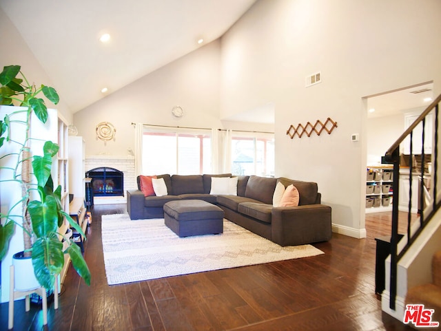 living room with a fireplace, dark hardwood / wood-style flooring, and high vaulted ceiling