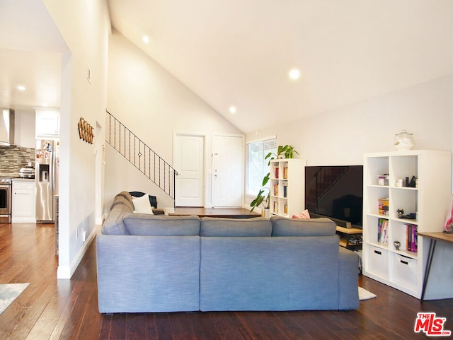 living room with dark hardwood / wood-style flooring and high vaulted ceiling