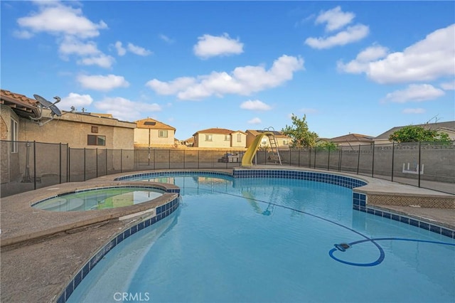 view of pool featuring an in ground hot tub and a water slide