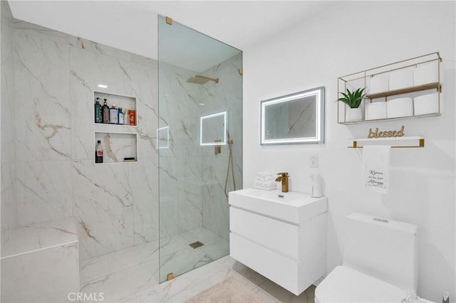 bathroom featuring tiled shower, vanity, and toilet