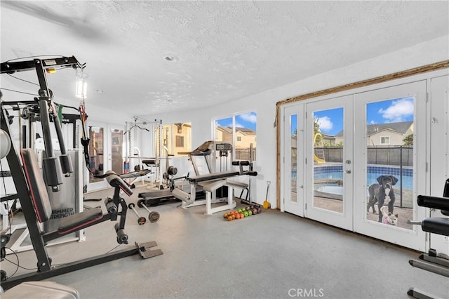 workout area featuring french doors and a textured ceiling