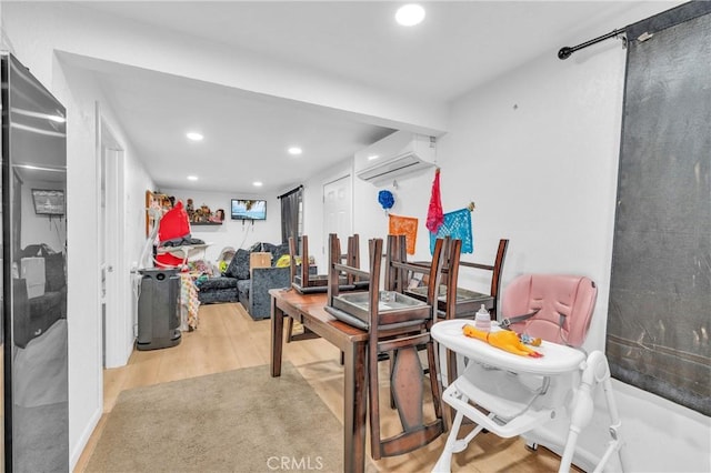 interior space with a wall unit AC and light hardwood / wood-style flooring