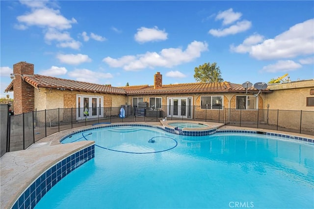 view of swimming pool featuring an in ground hot tub and french doors