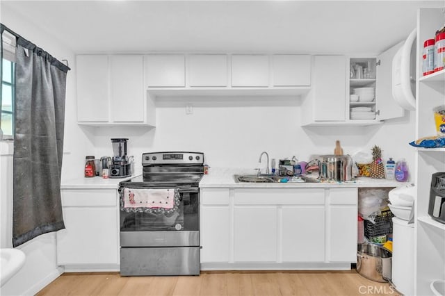 kitchen featuring light wood-type flooring, sink, white cabinetry, and stainless steel electric range