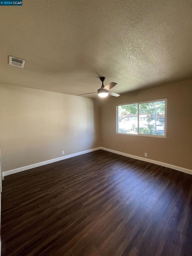 spare room featuring a textured ceiling, dark hardwood / wood-style flooring, and ceiling fan