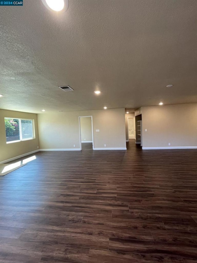 unfurnished room featuring a textured ceiling and dark wood-type flooring