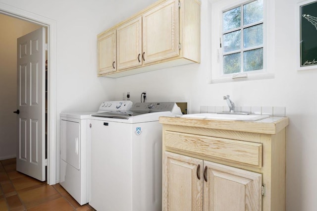 washroom with tile patterned flooring, washer and dryer, cabinets, and sink