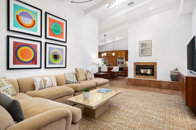 living room featuring tile patterned flooring, lofted ceiling with beams, and a tile fireplace