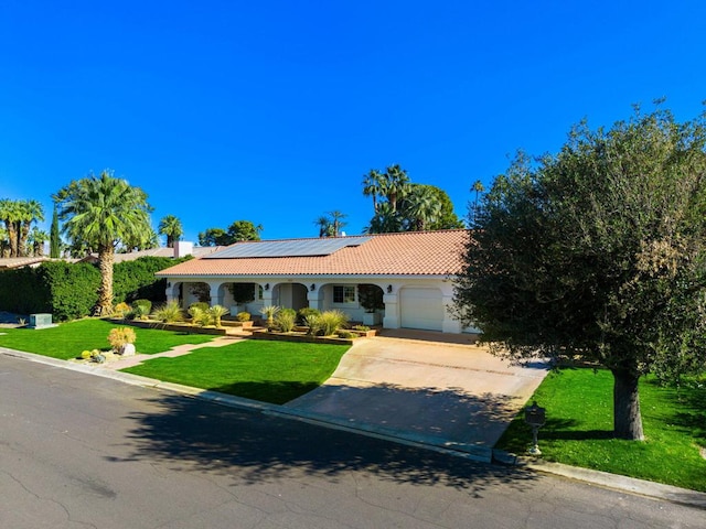 view of front of property featuring solar panels, a front lawn, and a garage