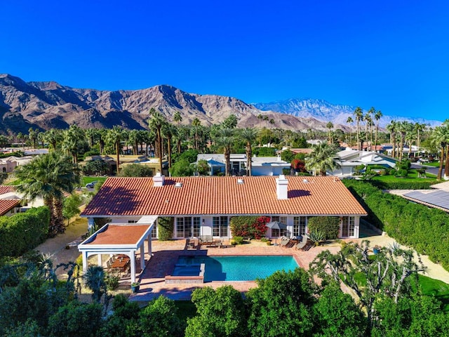 rear view of house with a mountain view and a patio