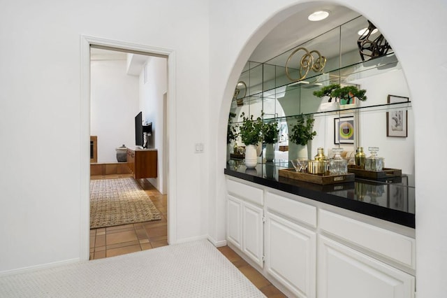 bar featuring white cabinets and light tile patterned floors