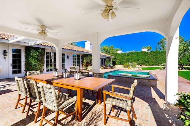 view of patio featuring ceiling fan and a swimming pool with hot tub