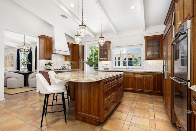 kitchen featuring beam ceiling, hanging light fixtures, tasteful backsplash, light stone counters, and appliances with stainless steel finishes