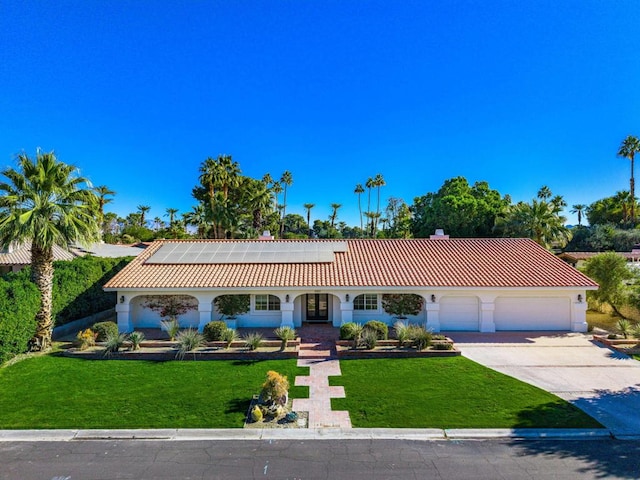 view of front of home featuring a front lawn, a garage, and solar panels