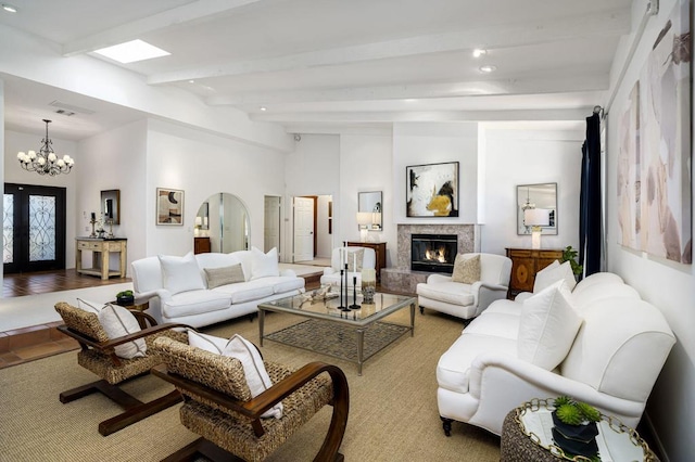 living room with a high end fireplace, french doors, light hardwood / wood-style flooring, vaulted ceiling with beams, and a chandelier