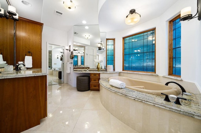 bathroom featuring tile patterned flooring, a bath, and vanity