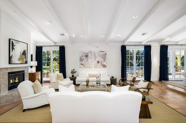 living room featuring a high end fireplace, beam ceiling, and a healthy amount of sunlight